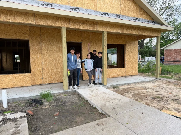 Family standing in front of a house that is under construction